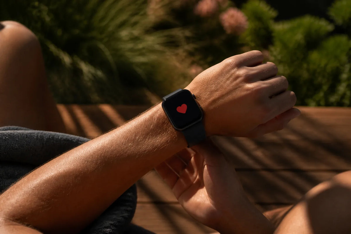 Barrel 250 - Outdoor-Sauna für 6-8 Personen mit einer Nahaufnahme einer Smartwatch, die nur ein rotes Herzsymbol zeigt